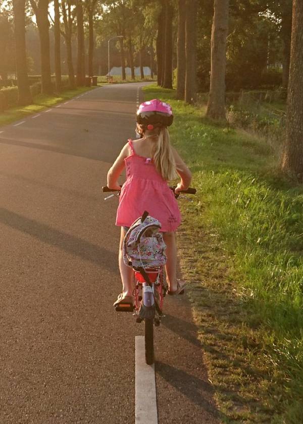 Niña en bicicleta circulando correctamente por la derecha